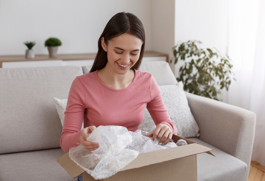 Attractive young girl unboxing international delivery order